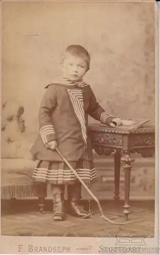 Portrait Kind in Matrosenkleid mit Peitsche, Fotografie. Fotobild