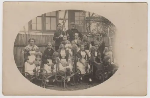 AK Gruppenfoto Spinnerei - Frauen in Tracht mit Spinnrad und 2 Männer in Uniform