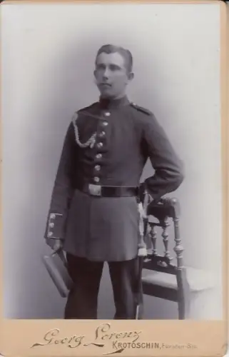 Fotografie:  Atelier Georg Lorenz, Portrait Mann in Uniform mit Mütze und Säbel