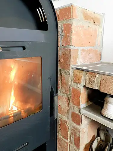 Ofen Verkleidung Kaminecke Gestaltung Wohnzimmer Backstein Rückwand alte Ziegel Riemchen Landhaus