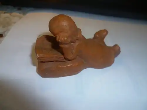  Modell  eines lesenden auf dem Boden liebenden Mädchens Keramik in braun bemaltZeit des Historismus  um 1890 H : 45 mm signiert DTS