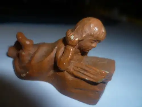  Modell  eines lesenden auf dem Boden liebenden Mädchens Keramik in braun bemaltZeit des Historismus  um 1890 H : 45 mm signiert DTS