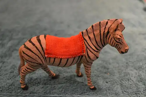 Spielzeugfigur, Tierfigur aus Masse, etwa 1930,Zebra mit Sattel, handbemalt