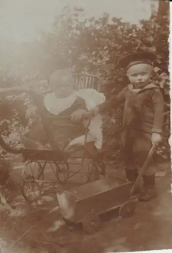 Fotografie, s/w, Kinderim Kinderwagen und Bollerwagen, etwa 1900
