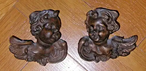 Putti – 2 Engelsköpfe holzgeschnitzt, dunkel gefaßt, ca. Anfang 20. Jahrhundert