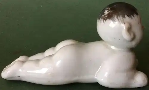 Kleine liegende asiatische Porzellanfigur, ohne Marke