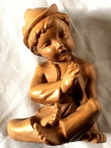 Holzgeschnitzte Figur, sitzender Junge mit Hut