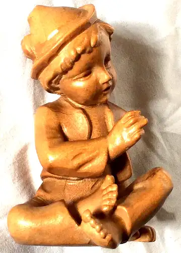 Holzgeschnitzte Figur, sitzender Junge mit Hut