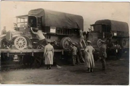 Photographie 1. Weltkrieg: Soldaten beim Verladen von Militär-LKWs, ca. 1917