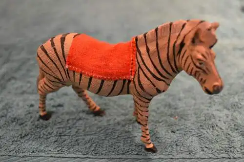 Spielzeugfigur, Tierfigur aus Masse, etwa 1930,Zebra mit Sattel, handbemalt