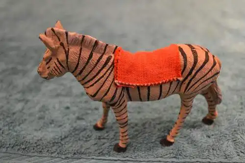 Spielzeugfigur, Tierfigur aus Masse, etwa 1930,Zebra mit Sattel, handbemalt