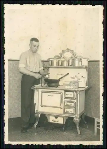 Foto Junger Mann Spiegeleier braten an Kochmaschine Gusseiserner Kohleherd 1933