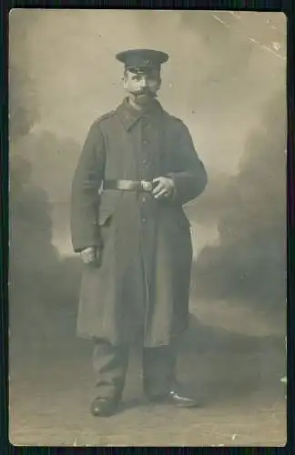 AK 1. WK Soldat Stand-Portrait auf Mantelkragen ?35 mit Mütze und Koppel 1915