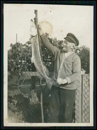 Älterer Mann hält stolz seinen großen gefangenen Hecht im Garten zur Schau 1936