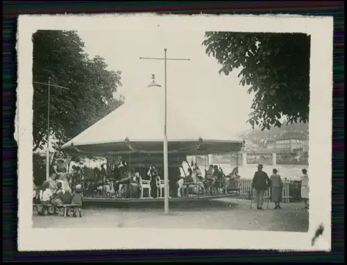 Foto - Kinder-Karussell an der Donau in Passau ?- Hintergrund Brücke Stadthäuser