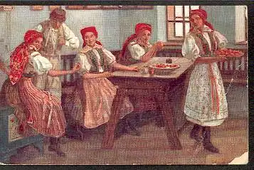 Vier Frauen und ein Mann in Tracht am Tisch.