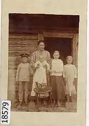 Familie vor dem Eingang eines Bauernhauses. Foto