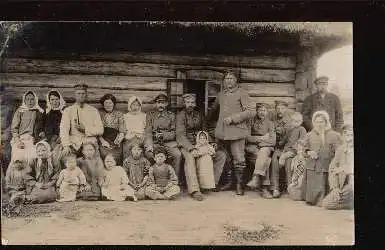 Gruppenfoto vor einer Blockhütte (Bauernhaus). Foto