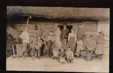 Gruppenfoto vor einer Blockhütte. (Bauernhaus)