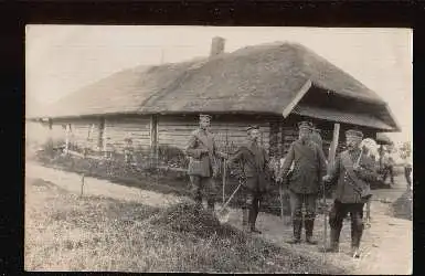 Männer vor einem Bauernhaus. Foto