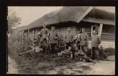 Männer vor einem Bauernhaus. Foto