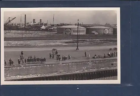 [Ansichtskarte] Photo AK Mole mit Menschen und im Hintergrund Tanks Bunkerstation Essolub und Industrie. 