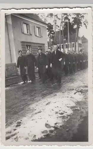 (F9963) Orig. Foto Männer (Soldaten?) marschieren durch einen Ort, 1940er