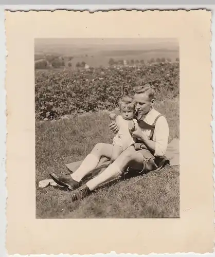 (F9363) Orig. Foto Mann mit Kleinkind sitzt auf der Wiese, 1930er