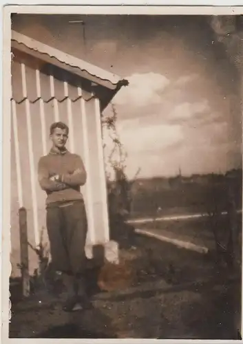 (F8290) Orig. Foto junger Mann steht im Garten an einem Holzhäuschen, 1930er