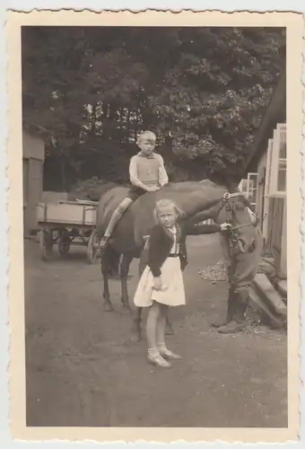(F29322) Orig. Foto Junge sitzt auf Pferd, Mädchen hält 1940er