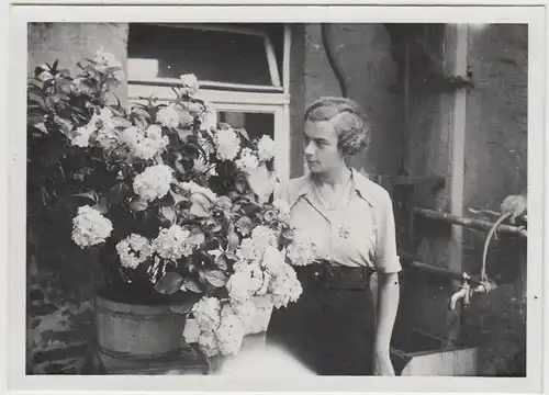 (F28777) Orig. Foto junge Frau mit Blumen am Haus 1938