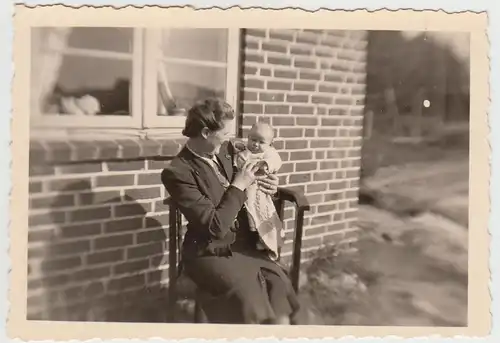 (F26082) Orig. Foto Frau m. Kleinkind auf dem Arm am Haus 1943