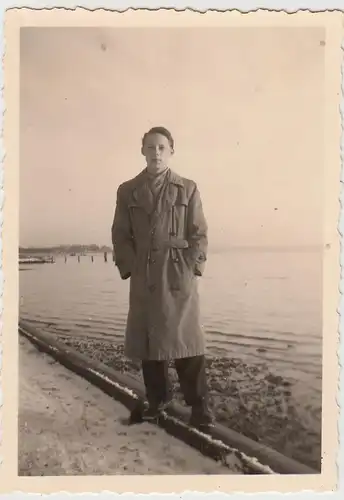 (F26056) Orig. Foto junger Mann mit Mantel am Wasser 1955