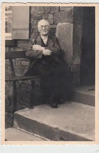 (F24472) Orig. Foto älterer Herr sitzt auf Bank am Haus, nach 1945