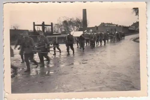 (F23399) Orig. Foto deutsche Soldaten schleppen Gegenstände durch e. Ort 1940er