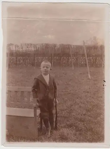 (F21114) Orig. Foto kleiner Junge mit Gewehr an einer Bank 1910er