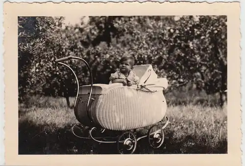 (F20784) Orig. Foto Kind sitzt in einem Korb-Kinderwagen 1930er