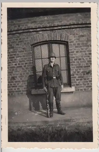 (F14415) Orig. Foto deutscher Soldat mit Gewehr u. Stahlhelm vor Gebäude 1940er