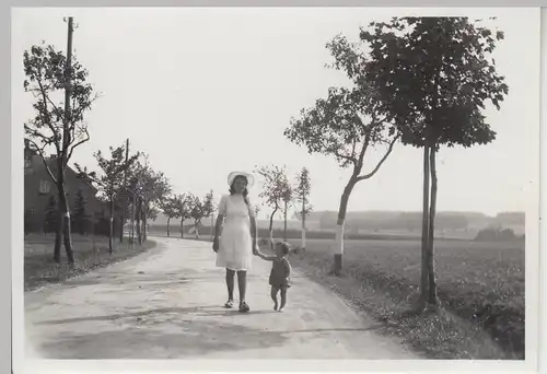 (F13693) Orig. Foto junge Frau mit Kind spaziert auf Landstraße 1943