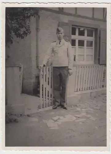 (F13491) Orig. Foto Luftwaffe-Soldat steht am Zaun vor Haus 1940er