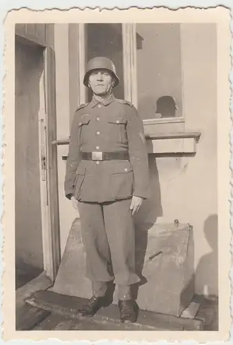 (F11497) Orig. Foto Wehrmacht-Soldat mit Stahlhelm vor einer Haustür "Auf Wache"