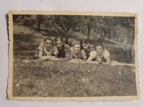 Drei Frauen und zwei Soldaten auf einer Wiese