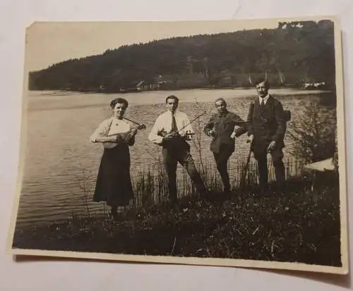 Personen am See mit Instrumenten