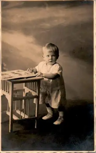 alte foto ak, kind stehend an kindertisch (Nr. 9173)