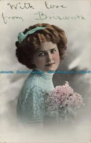 R650540 Frau mit Blumen in der Hand und einem Band im Haar. 1912