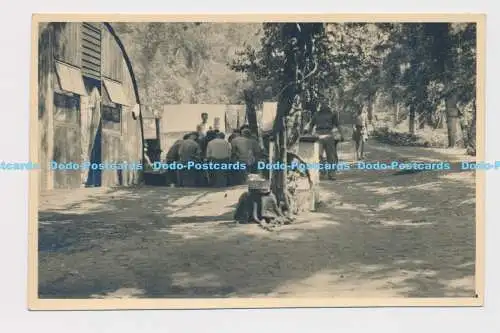 C016463 Village. Die Männer sitzen an einem Tisch am Gebäude