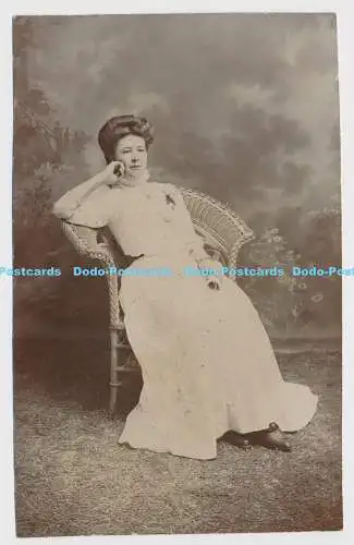 C024518 Eine Frau in einem langen Kleid sitzt auf einem Stuhl. Arthur Whitaker