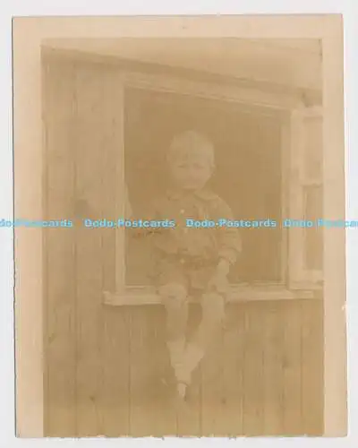 C024522 Auf der Fensterbank sitzt ein kleiner Junge
