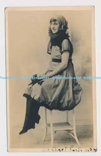 C025019 Junge Frau im Kleid mit Schal sitzt auf Sessel