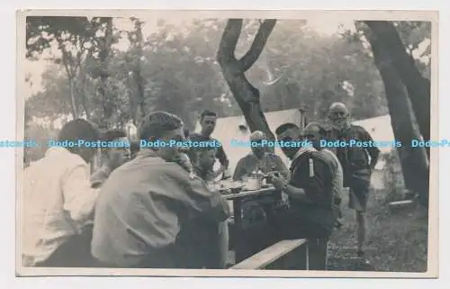 C025064 Pfadfinderlager. Männer sitzen am Tisch. Jerome